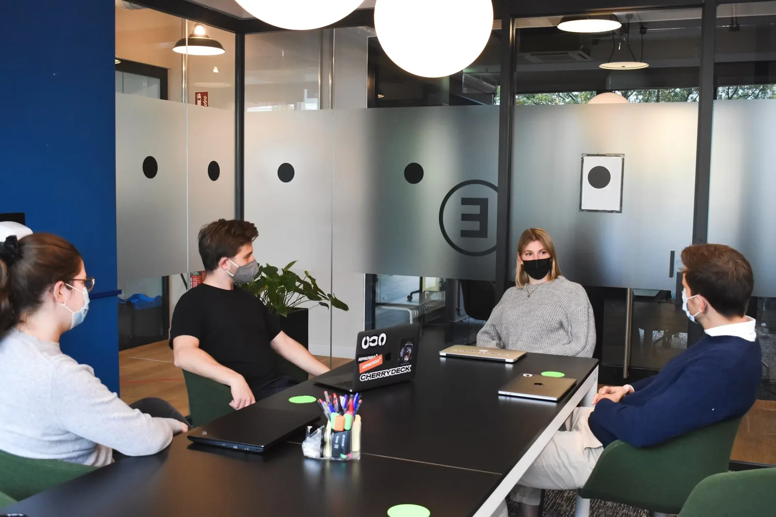 Besprechung an einem Tisch mit Laptops in einem hellen Büro